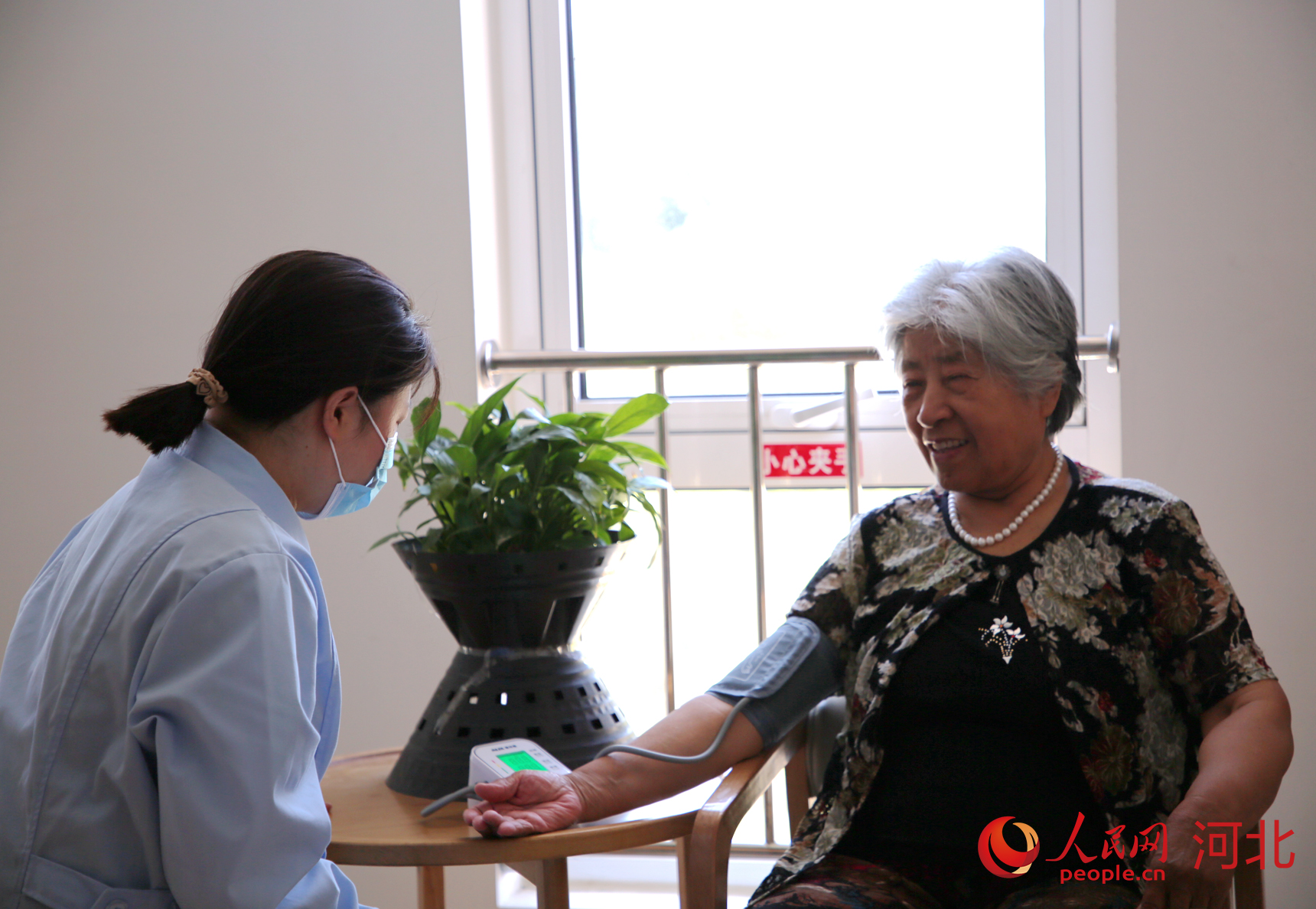 承德市壽康康養(yǎng)中心的醫(yī)護(hù)人員為入住長(zhǎng)者測(cè)量血壓。人民網(wǎng)記者 周博攝