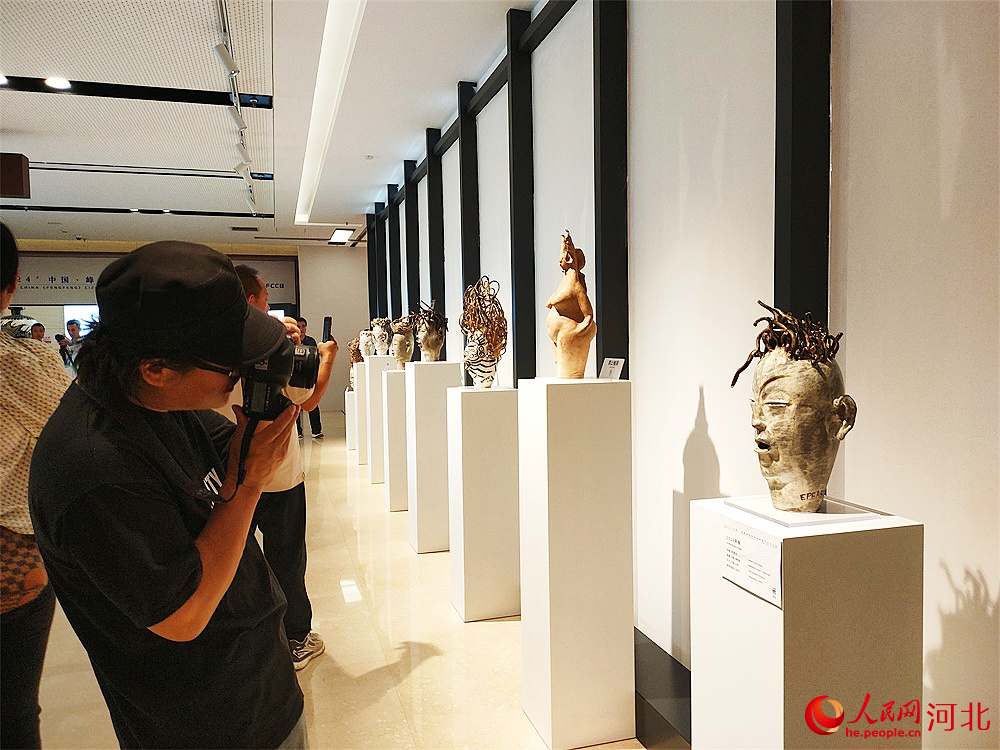 參觀者正在拍攝陶瓷藝術(shù)作品。人民網(wǎng)記者 楊文娟攝