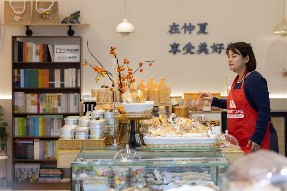 仲夏一心蛋糕面包集合店店主康盼盼騰出店里最好的位置放置書架。主辦方供圖