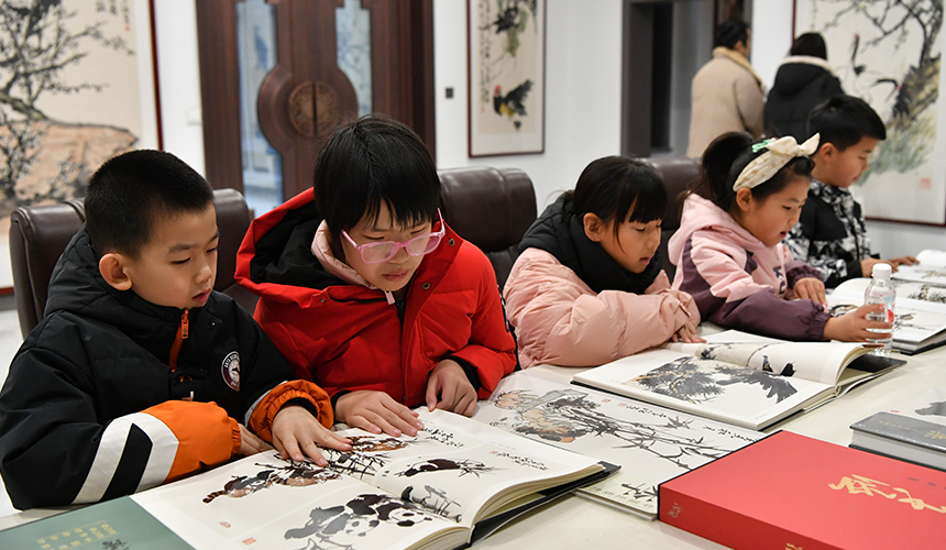 12月22日，孩子們正在遷安市李涵美術(shù)館參觀畫冊(cè)。張澤慧攝