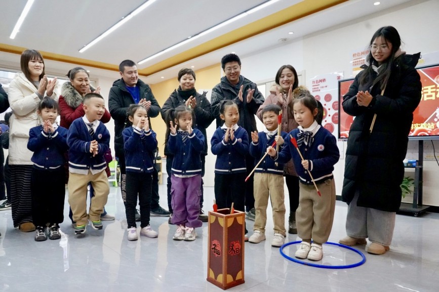 12月30日，在保定市競(jìng)秀區(qū)先鋒街道華南社區(qū)，小朋友和家長(zhǎng)一起投壺。石璐琪攝
