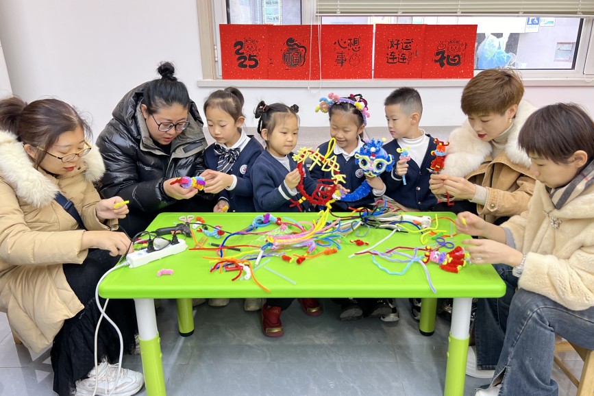 12月30日，在保定市競秀區(qū)先鋒街道華南社區(qū)，小朋友和家長一起用扭扭棒制作小花蛇。王雅璇攝