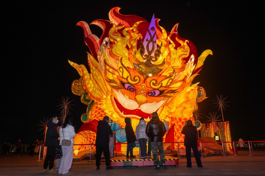 河北省唐山市南湖旅游景區(qū)，游客與“年獸”互動(dòng)。趙杰攝