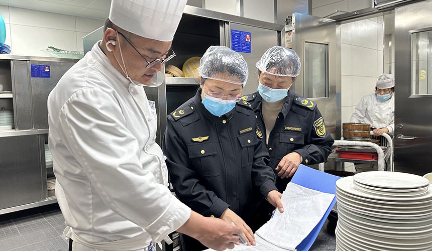 執(zhí)法人員檢查餐飲單位餐具消毒情況。齊東青攝