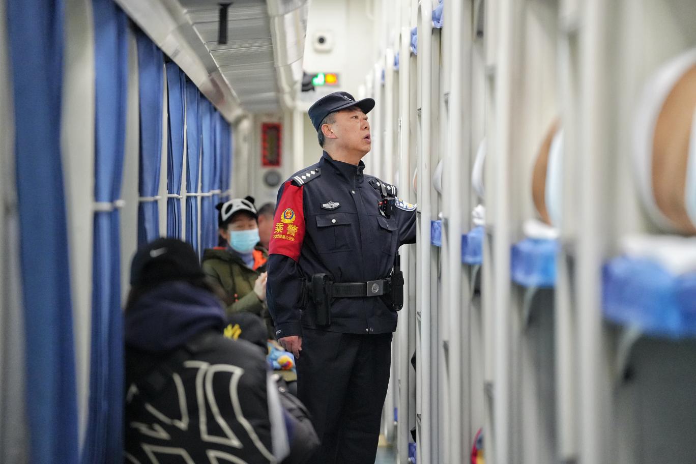 K7708次列車乘警錢振峰在車廂加大巡查頻次，提醒旅客注意乘車安全。賈義涵攝