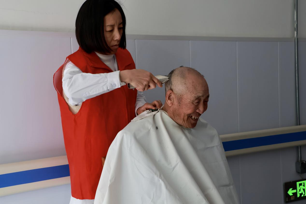 小集鎮(zhèn)的志愿者為敬老院的老人理發(fā)。聶思萌攝