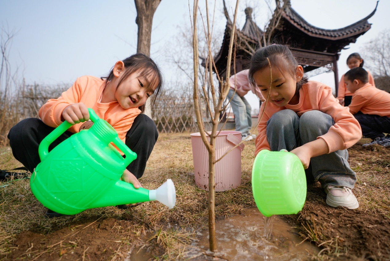 3月11日，黃驊市第一幼兒園小朋友在戶外植樹。張國文攝