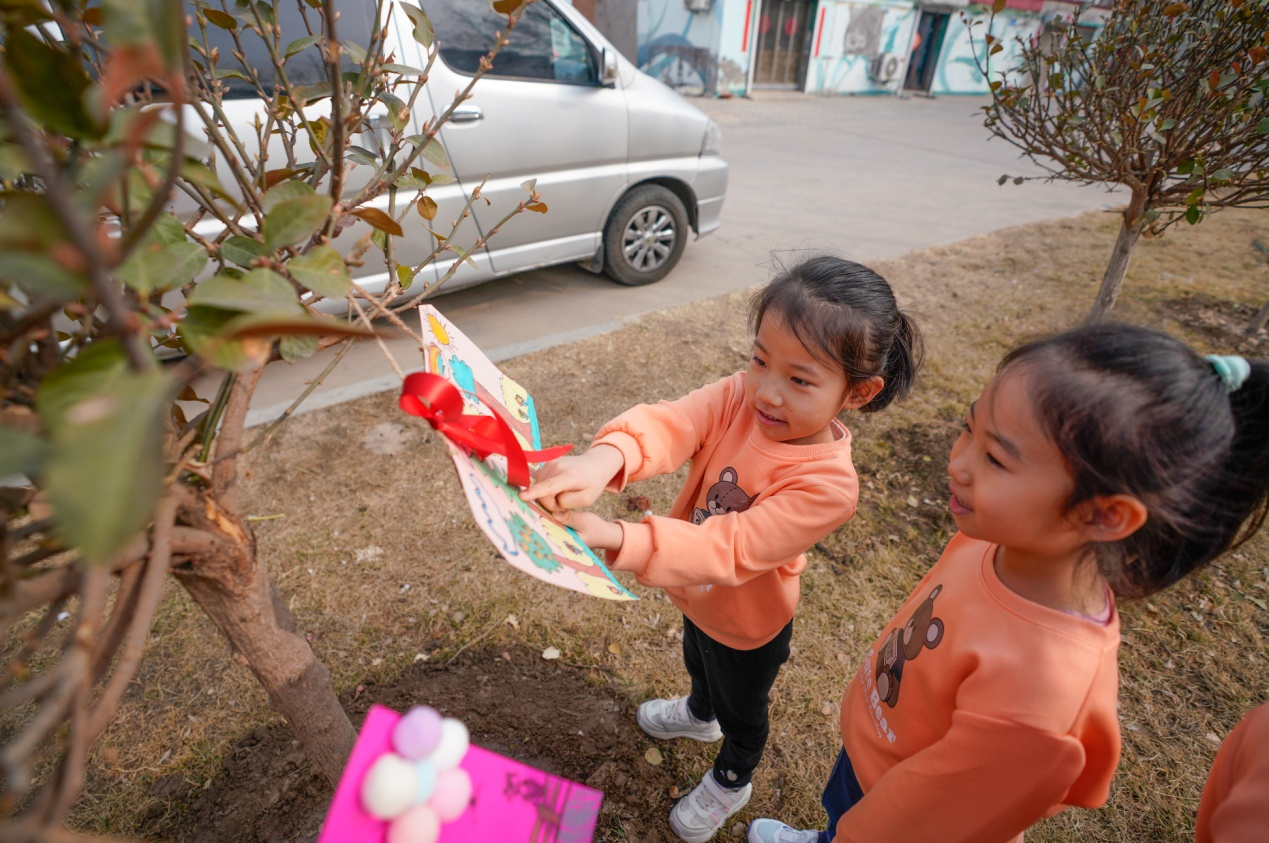 3月11日，黃驊市第一幼兒園小朋友手工制作的把護樹牌懸掛到樹上。張國文攝